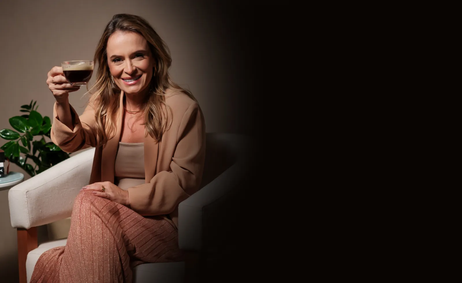 Kelly Rossoni brindando com uma xícara de café